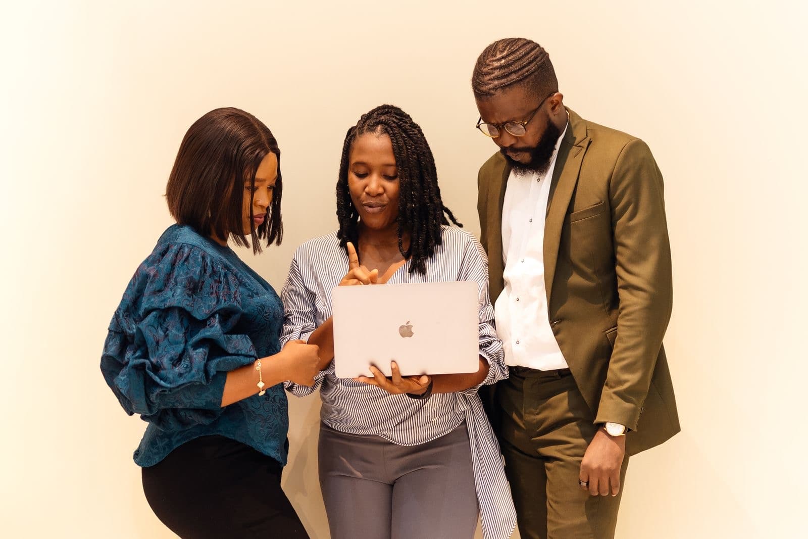 Three colleagues looking at a laptop together during a meeting