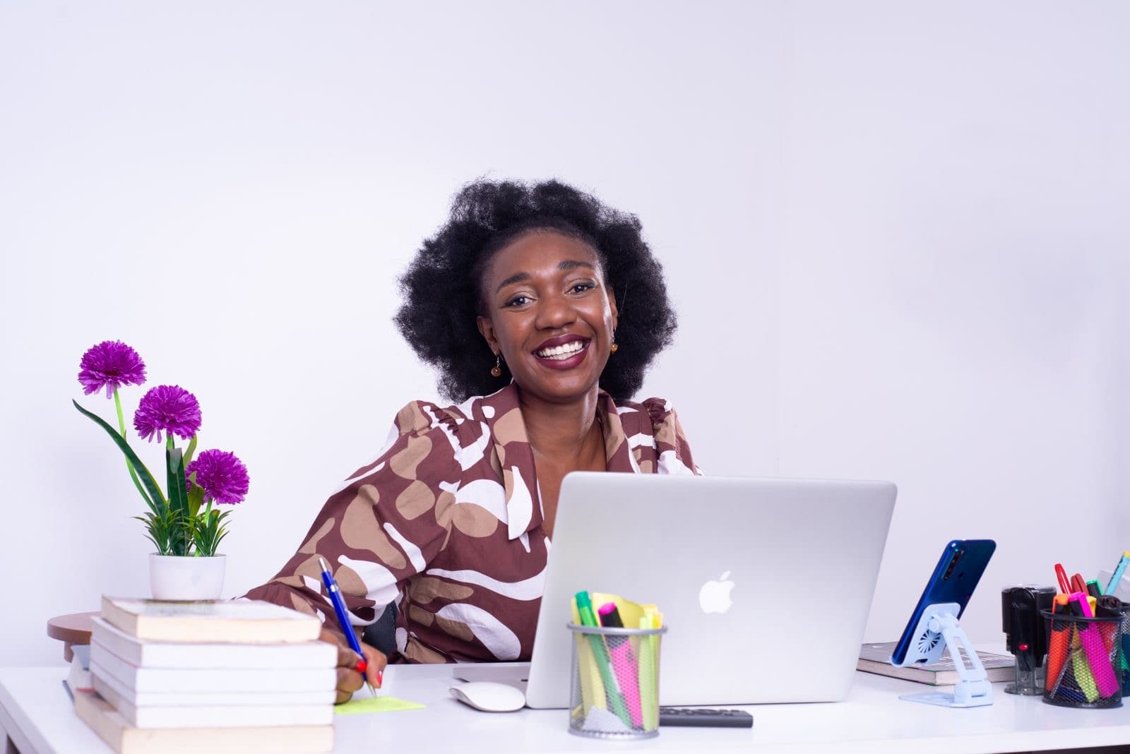 A smiling businesswoman at her desk with a laptop